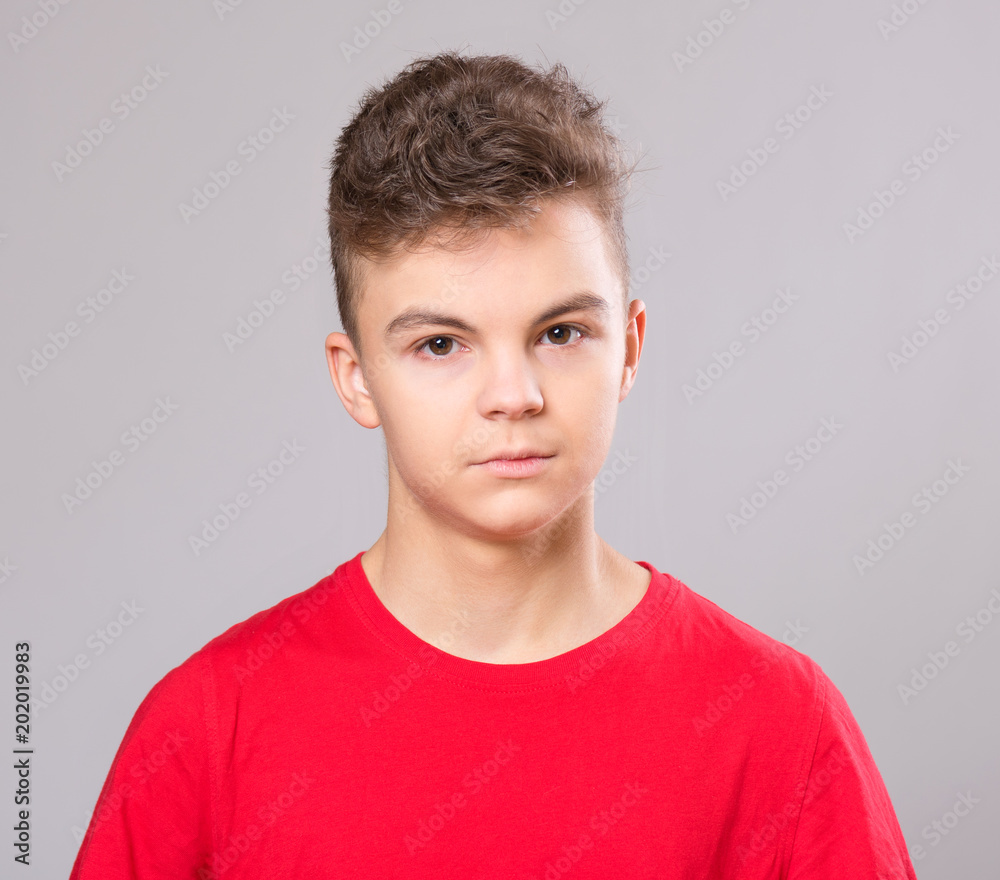 Close up emotional portrait of caucasian teen boy. Handsome smiling guy. Funny cut teenager on gray background. Child looking at camera. Close up emotional portrait of caucasian teen boy. Handsome smiling guy. Funny cut teenager on gray background. Child looking at camera.