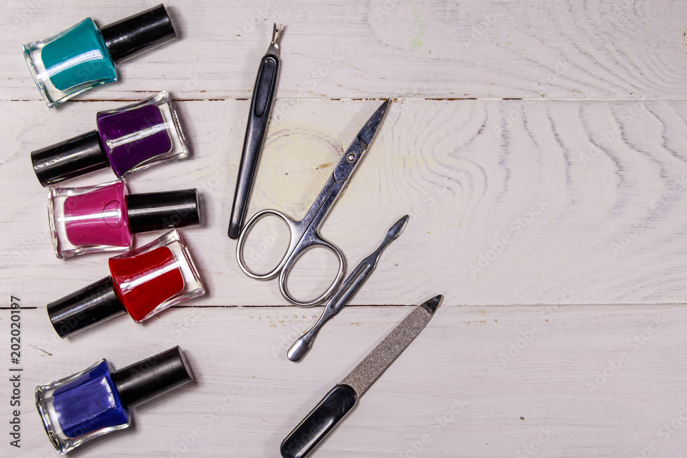 Basic set of manicure tools on white wooden background Basic set of manicure tools on white wooden background