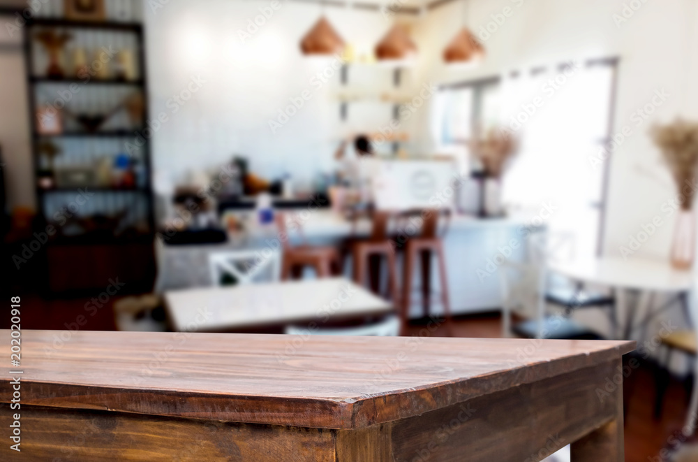 Selected focus empty brown wooden table and Coffee shop or restaurant blur background with bokeh image. for your photomontage or product display.