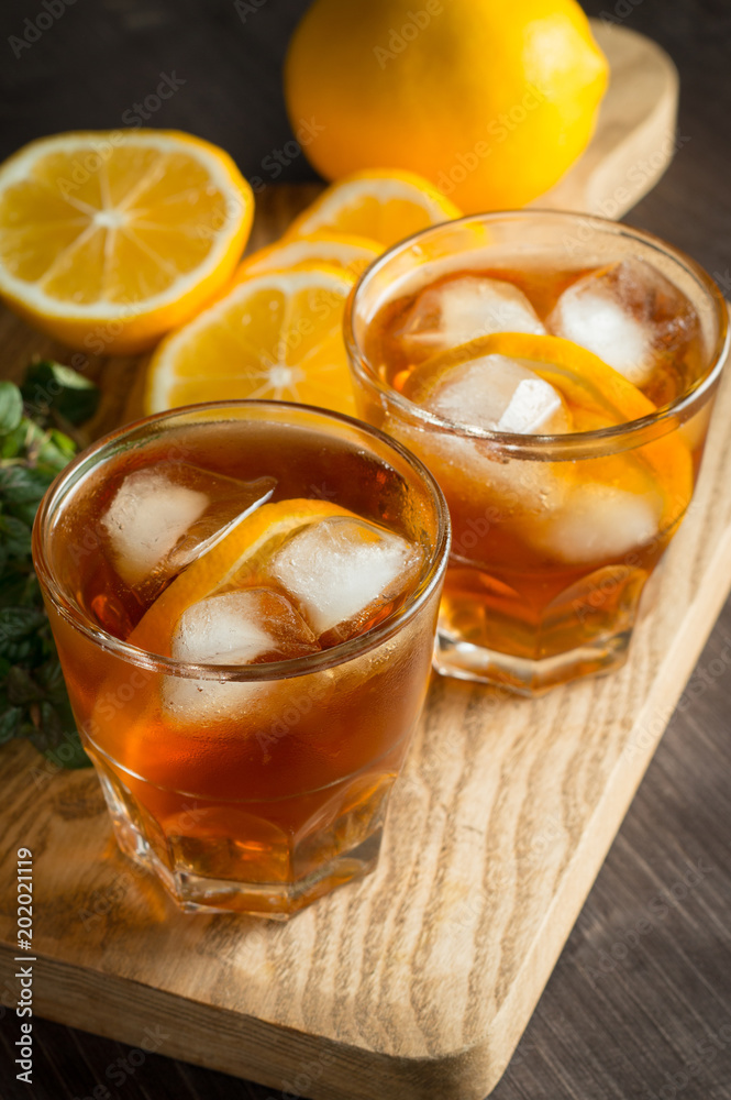 Glasses of cold ice tea with lemon, ice, mint on background. Homemade lemonade. Spring and summer drinks and beverages concept. Glasses of cold ice tea with lemon, ice, mint on background. Homemade lemonade. Spring and summer drinks and beverages concept.