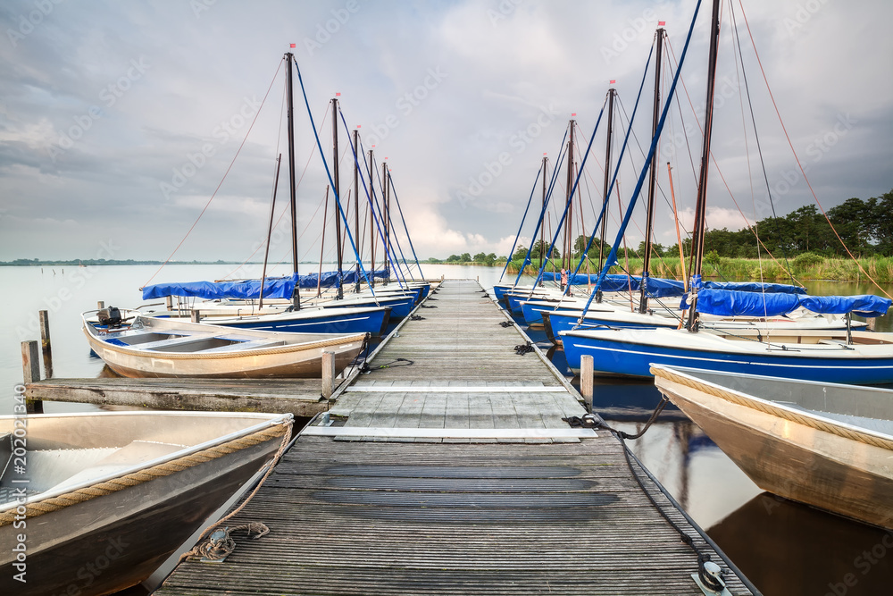 Fototapeta premium yachts and boats at pier on big lake