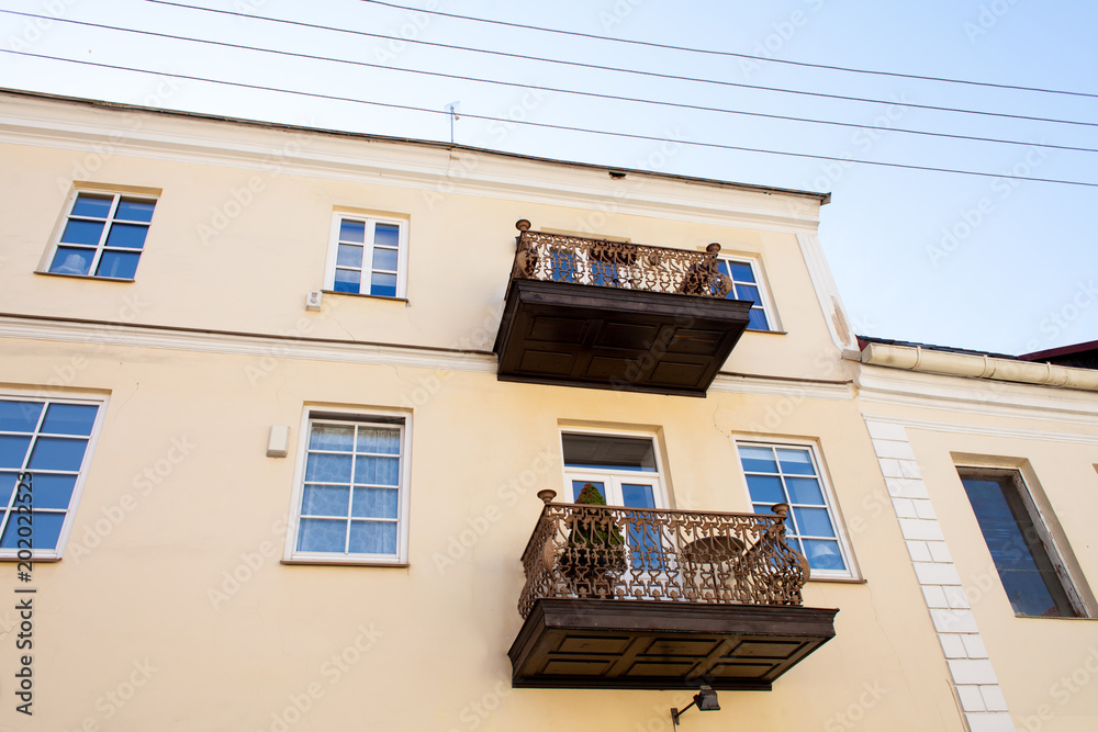 Old balconies, attics on a two-story apartment building with windows. Retro photo