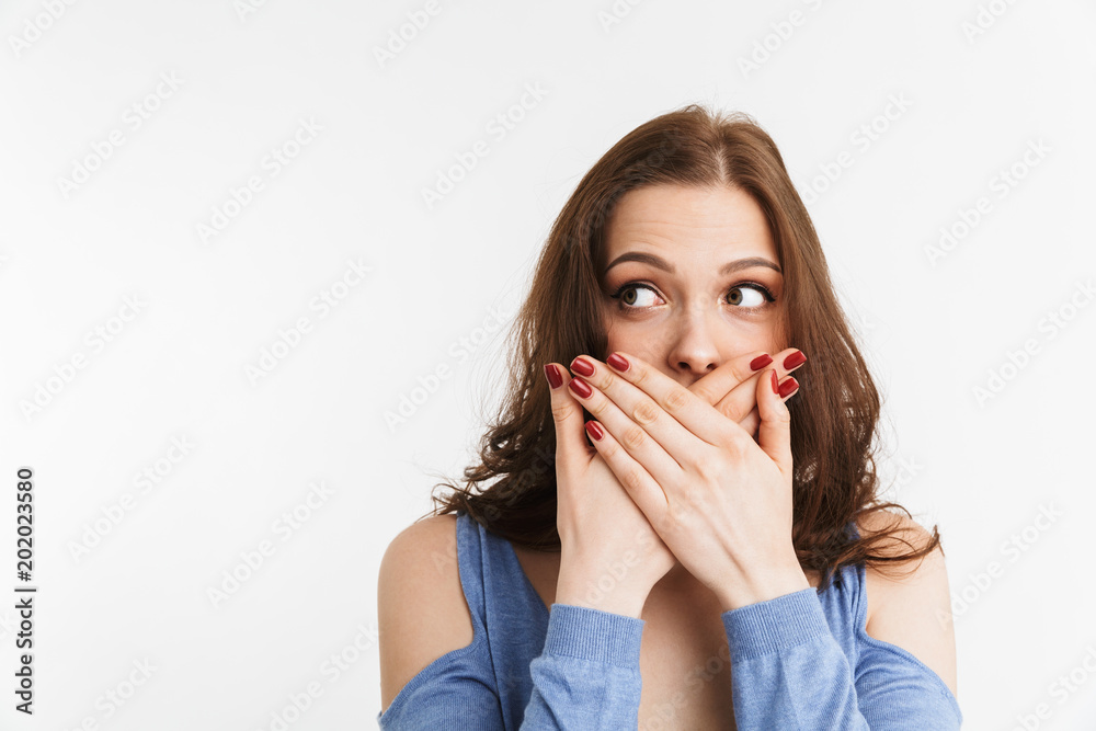 Portrait of a surprised young woman covering mouth Portrait of a surprised young woman covering mouth