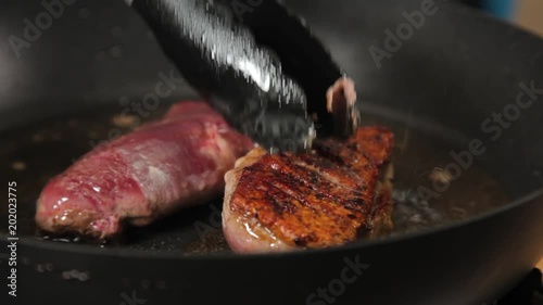 A close up shot hof duck breast meat being seared on a hot pan.