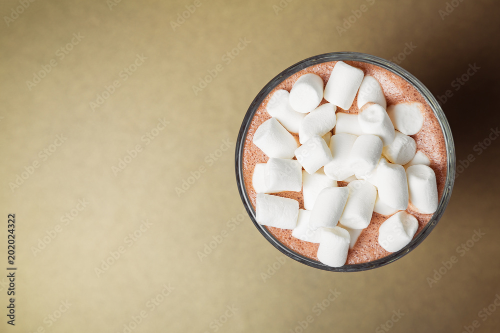 Glass cup of cacao with cream and marshmallow close-up on gold background. View from above Glass cup of cacao with cream and marshmallow close-up on gold background. View from above