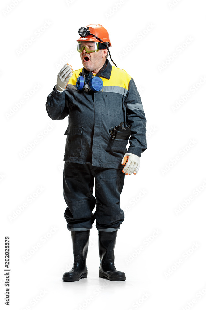 The studio shot of senior bearded male miner standing at the camera on a white background. The studio shot of senior bearded male miner standing at the camera on a white background.