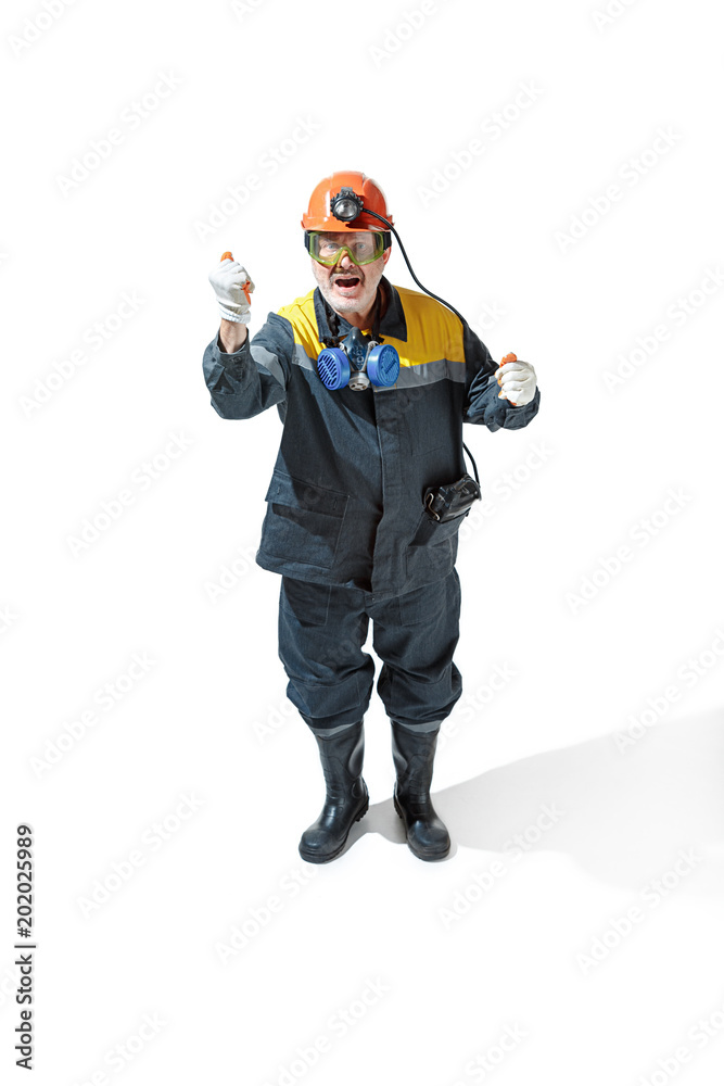 The studio shot of senior bearded male miner standing at the camera on a white background. The studio shot of senior bearded male miner standing at the camera on a white background.