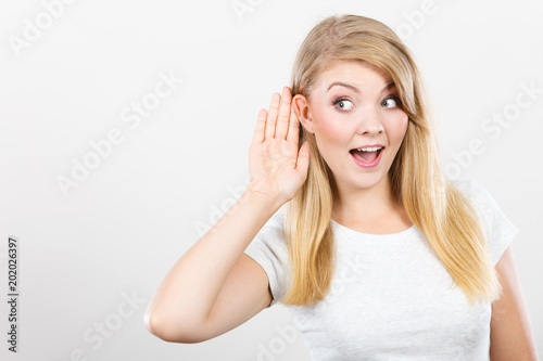 Woman putting hand ear to hear better