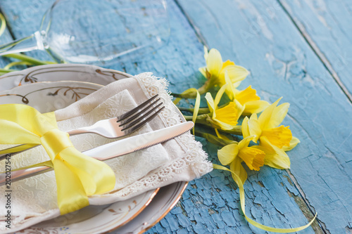Fototapeta Naklejka Na Ścianę i Meble -  Set of tableware and a bouquet of yellow narcissus