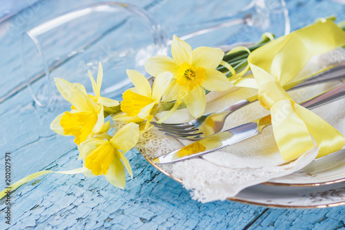 Fototapeta Naklejka Na Ścianę i Meble -  Set of tableware and a bouquet of yellow narcissus
