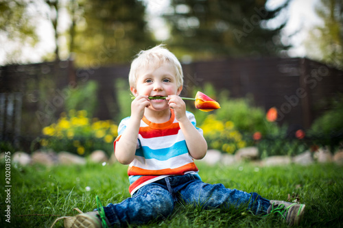 kleiner Junge spielt mit Blumen