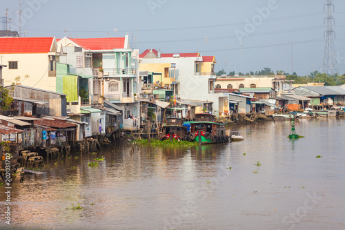 Houses by the river at Cai Be Floating Market of Mekong Delta. Cai Be Market is one of most famous floating market in Vietnam