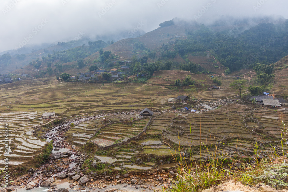 Sapa, view of Muong Hoa Valley with Black Hmong village of Y Linh Ho and terrace rice fields in Winter on foggy, rainy day.