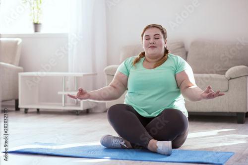 Power renewal. Concentrated young woman sitting in lotus posture while meditating