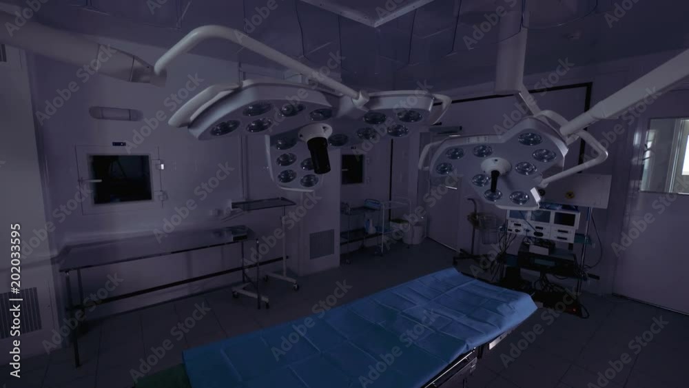An operating table and surgical light in a room. An operating table and surgical light in a room.
