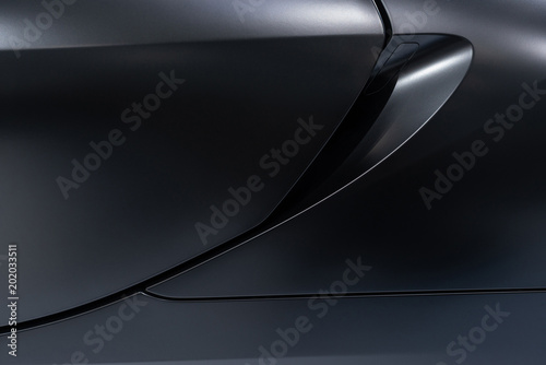 Abstract of dark silver car door surface with light reflection