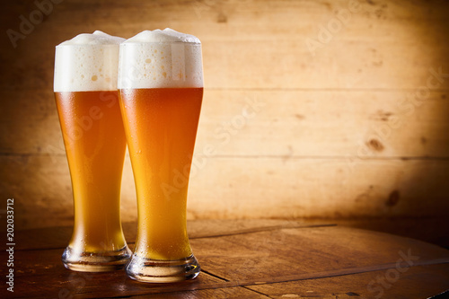 Ice cold glasses of frothy larger or wheat draft beer photo