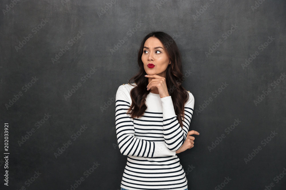Pensive brunette woman in sweater holding her chin Pensive brunette woman in sweater holding her chin