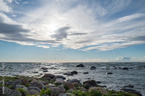 Cirrus clouds over a stone filled sea side