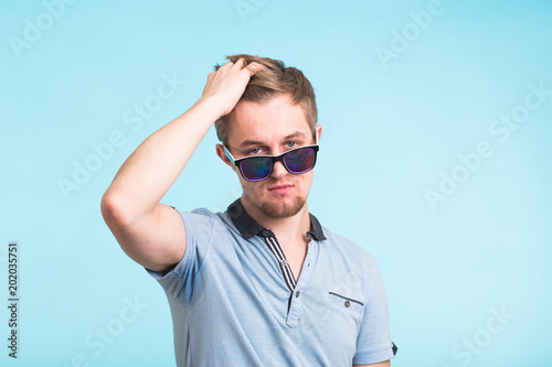 Portrait of a handsome man dressed in polo t-shirt on blue background