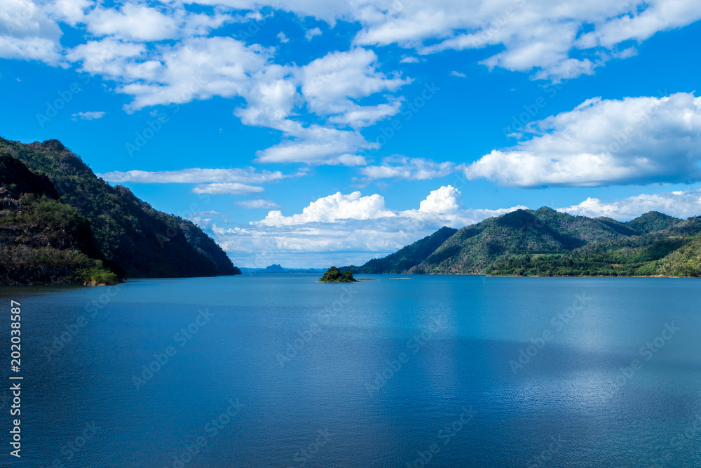 Wide view of beautiful landscape with river is vast dark indigo blue. Surrounded many mountains.