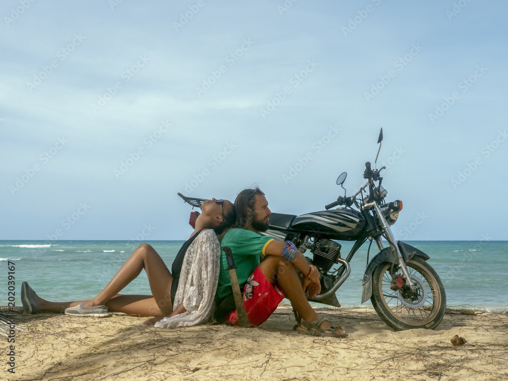 Fototapeta premium A man and a girl are traveling by motorcycle. Beach, sea