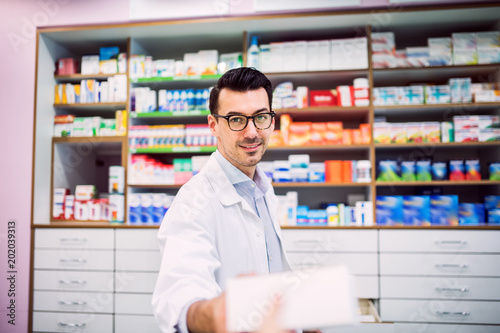 Portrait of a young friendly male pharmacist.