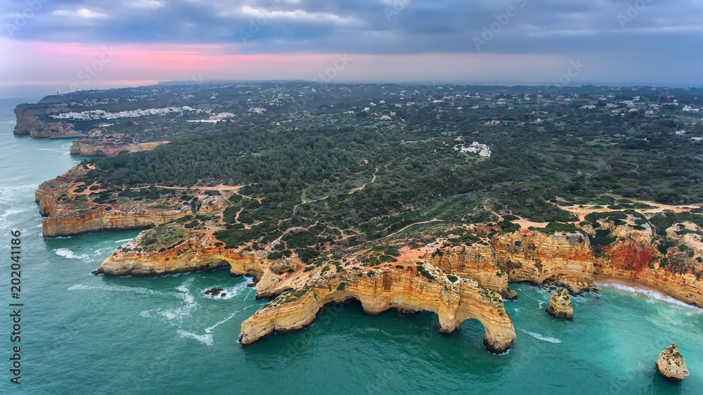 Aerial. Mountains and arches in the shape of a heart on the beach Marinha.