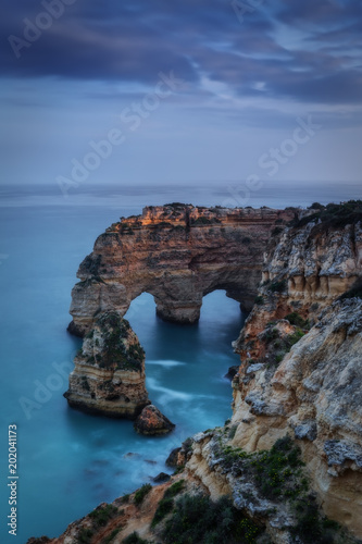 Mountains and arches in the shape of a heart on the beach Marinha. © sergojpg