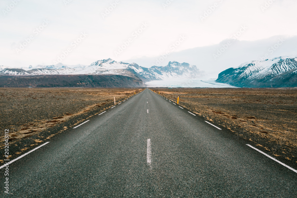 Empty straight road to mountains in Iceland