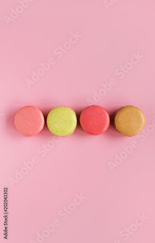 Colored macaroons on a pink  background , colorful almond cookies, pastel colors, vintage card, top view