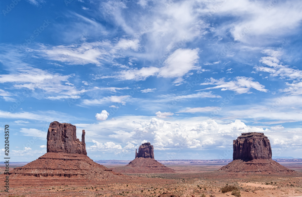 View of the famous Monument Valley, Colorado, USA, in daylight with blue sky full of clouds