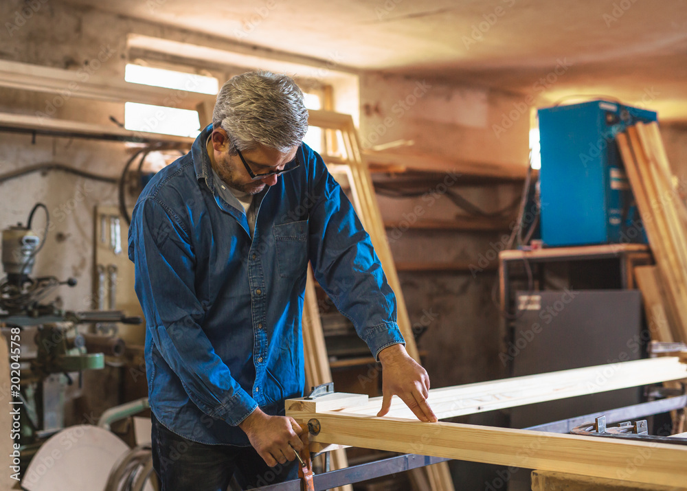 Mid-age gray hair carpenter working in his workshop Mid-age gray hair carpenter working in his workshop