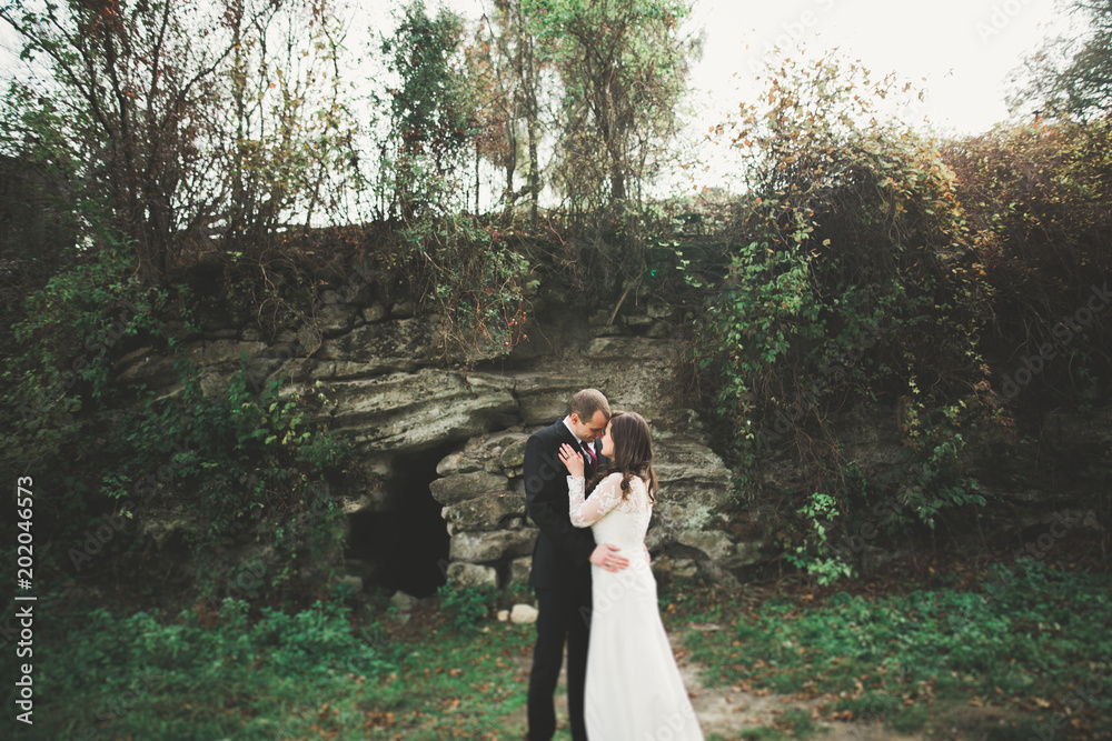 Beautiful romantic wedding couple of newlyweds hugging in park on sunset Beautiful romantic wedding couple of newlyweds hugging in park on sunset