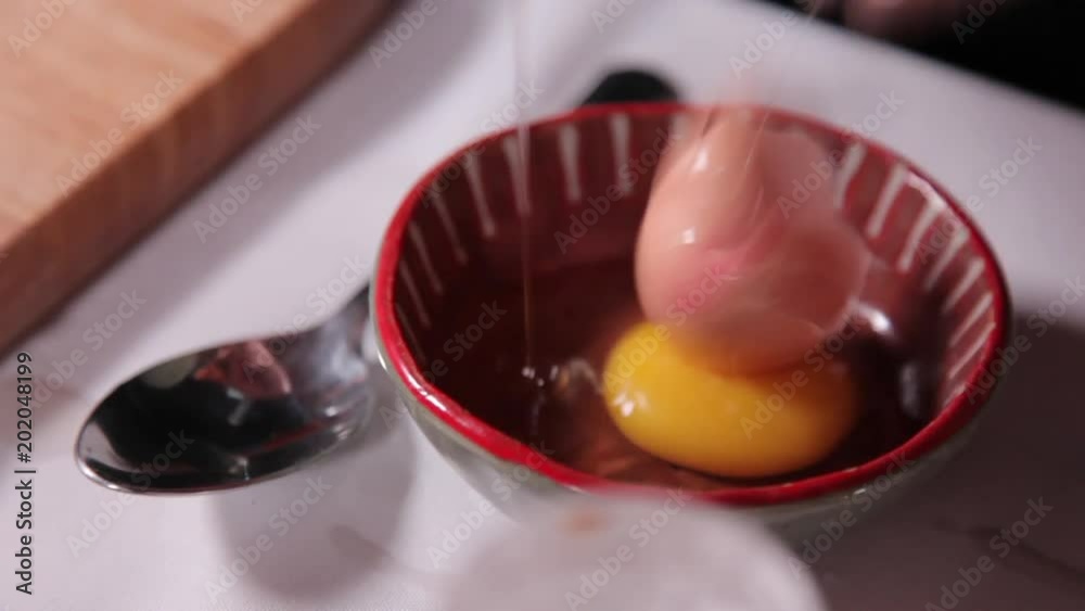 A close up shot of an egg that is cracked. A close up shot of an egg that is cracked.