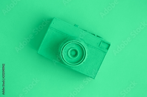 Flat lay of retro camera painted in green surrealism art concept.