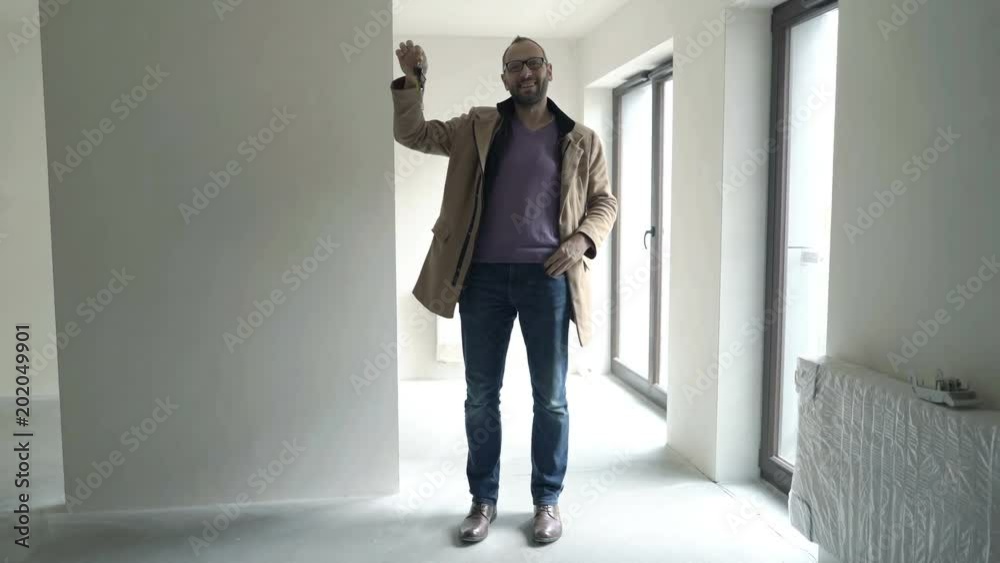 Young, happy man showing, playing with keys to his new home
Young, happy man showing, playing with keys to his new home