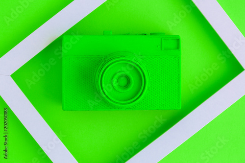 Flat lay of green painted vintage camera and photo frame background