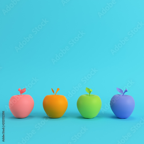 Four colorful apples on bright blue background in pastel colors