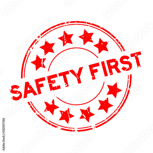 Grunge red safety first wording with star icon round rubber seal stamp on white background