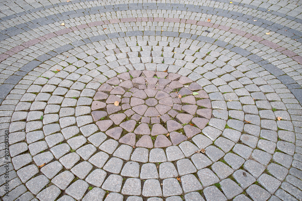 Concentric circles of pavement tile, abstract symmetric tile pattern