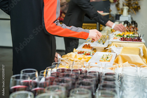 Catering buffet table with food and snacks for guests of the event. Group of people in all you can eat. Dining Food Celebration Party Concept. Service at business meeting, weddings. Selective focus.
