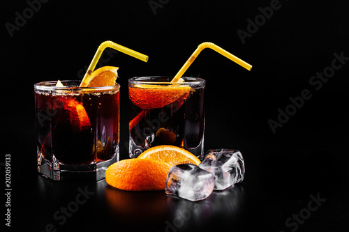 Rum and cola refreshing alcohol cocktail  drink in highball glass with orange and ice. photo