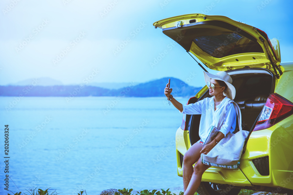 Asian woman travel nature. Travel relax. Sitting on the car