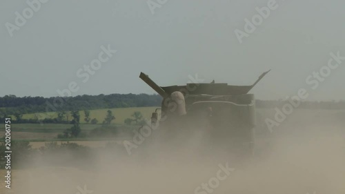 Combine harvesting wheat in field photo