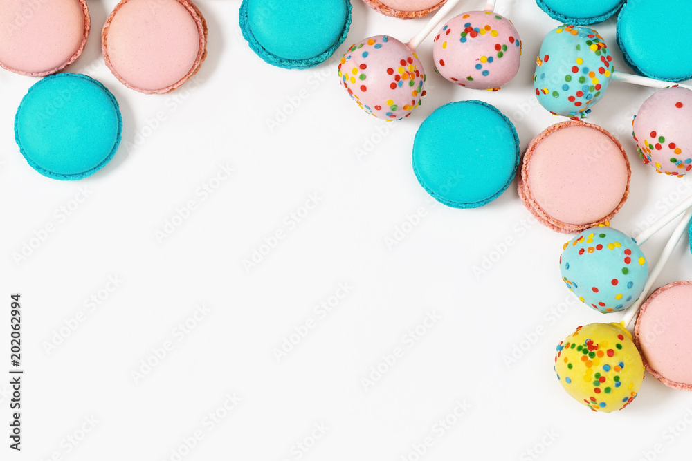 Multicolored macaroons and cake pops close up. Sweet dessert for background with copy space. Assorted cookies.