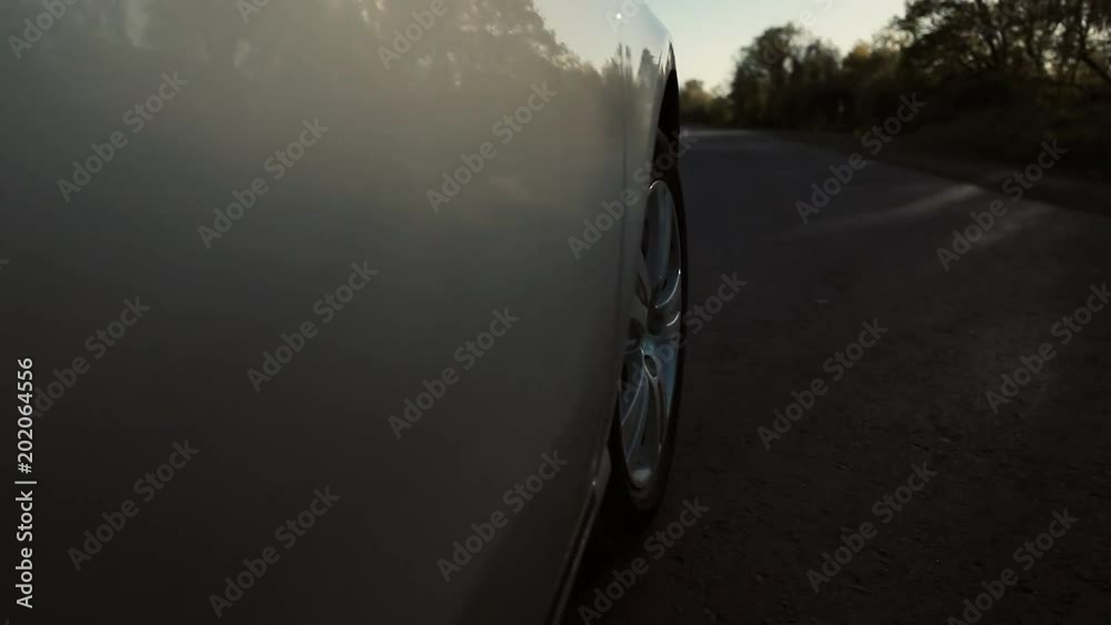 Driving a car is a country road. Wheel spinning POV