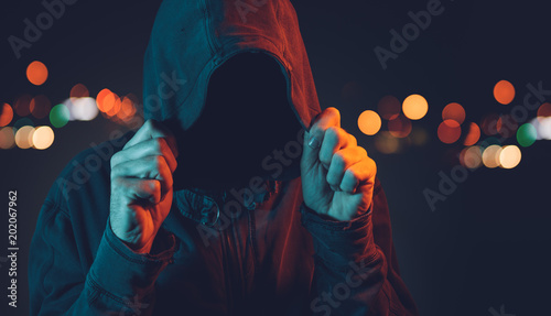 Faceless hooligan with hoodie in urban surrounding