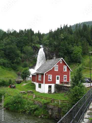 Red house and scenic waterfall in Norway