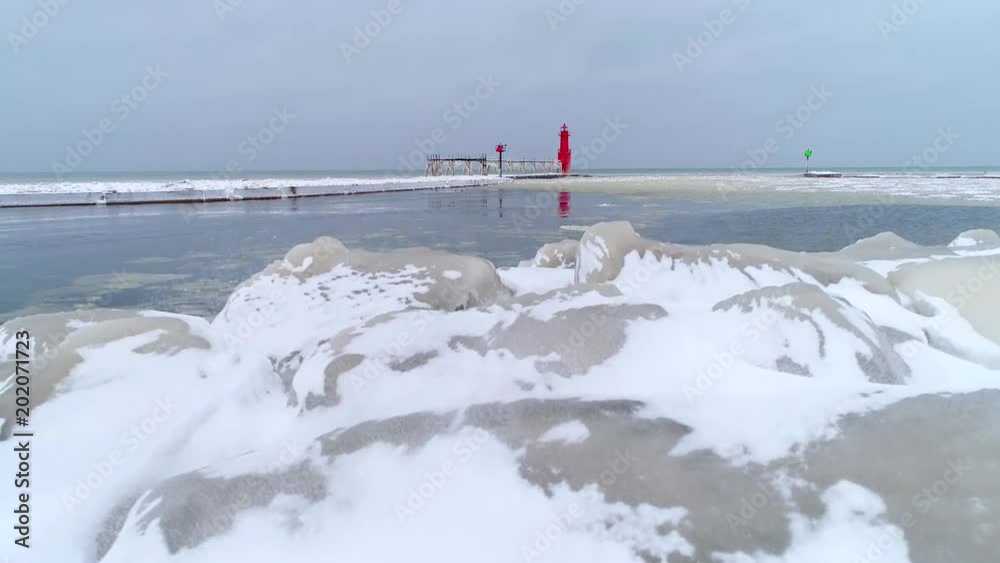 Scenic lighthouse with icicles on pier catwalk after storm, aerial view.
Scenic lighthouse with icicles on pier catwalk after storm, aerial view.